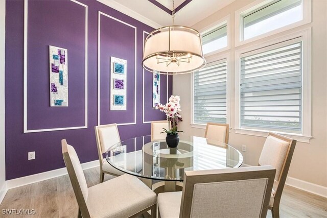 dining room with ornamental molding, a chandelier, and light wood-type flooring