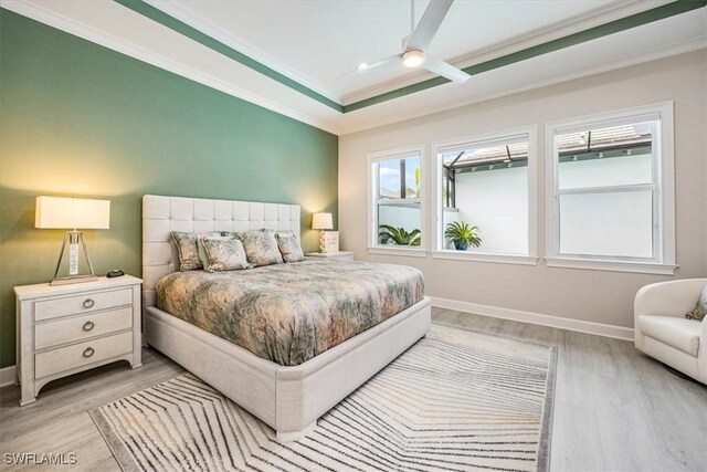 bedroom with ceiling fan, light hardwood / wood-style flooring, and multiple windows