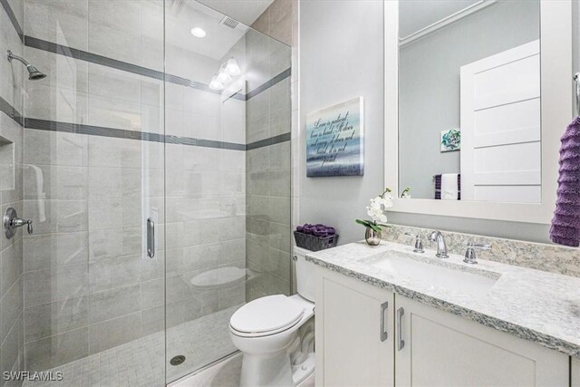 bathroom with vanity, toilet, and a shower with shower door