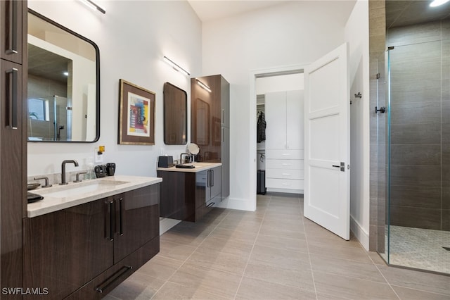 bathroom with a shower with shower door, vanity, and tile patterned flooring