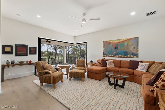 living room with ceiling fan and light hardwood / wood-style flooring