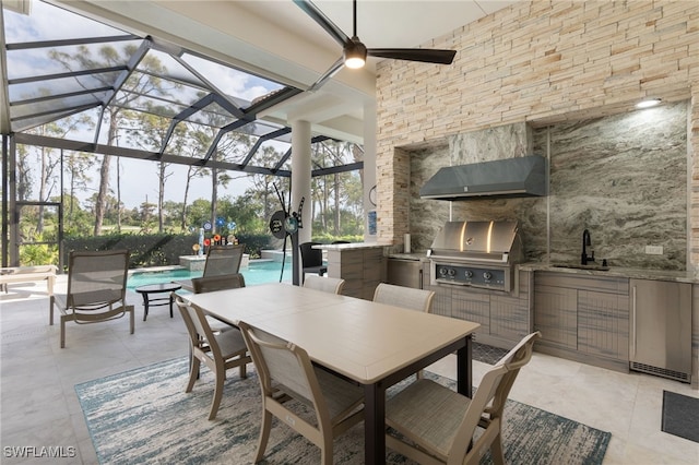 view of patio / terrace with ceiling fan, area for grilling, exterior kitchen, sink, and glass enclosure