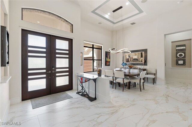 entrance foyer featuring a high ceiling, french doors, and a tray ceiling