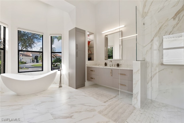 bathroom with vanity, independent shower and bath, and a high ceiling