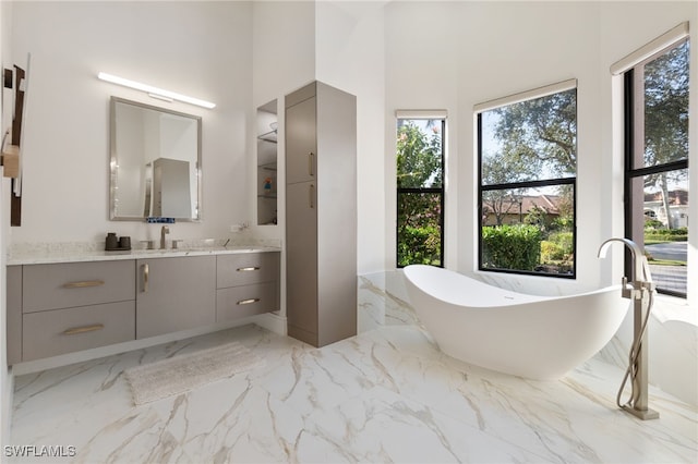 bathroom with a washtub and vanity