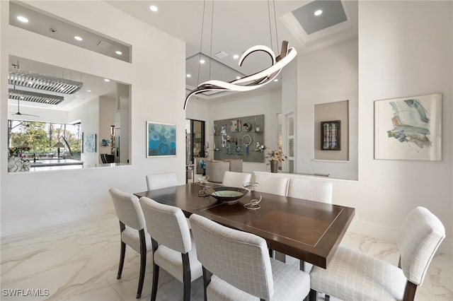 dining area featuring a high ceiling and ceiling fan