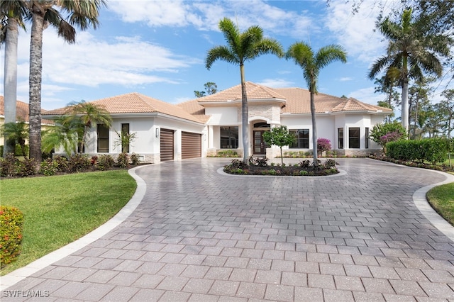 mediterranean / spanish-style home with a front lawn and a garage