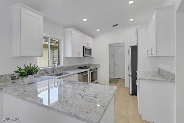 kitchen featuring appliances with stainless steel finishes, kitchen peninsula, light stone counters, white cabinets, and sink