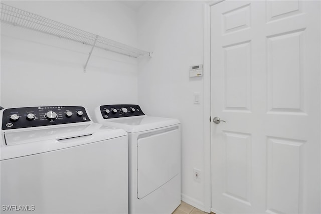 washroom with washer and dryer and light tile patterned floors