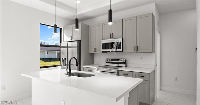 kitchen with gray cabinetry, sink, hanging light fixtures, and appliances with stainless steel finishes