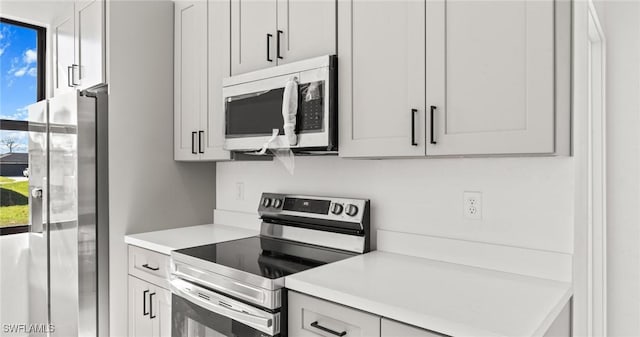 kitchen with white cabinets, a healthy amount of sunlight, and stainless steel appliances