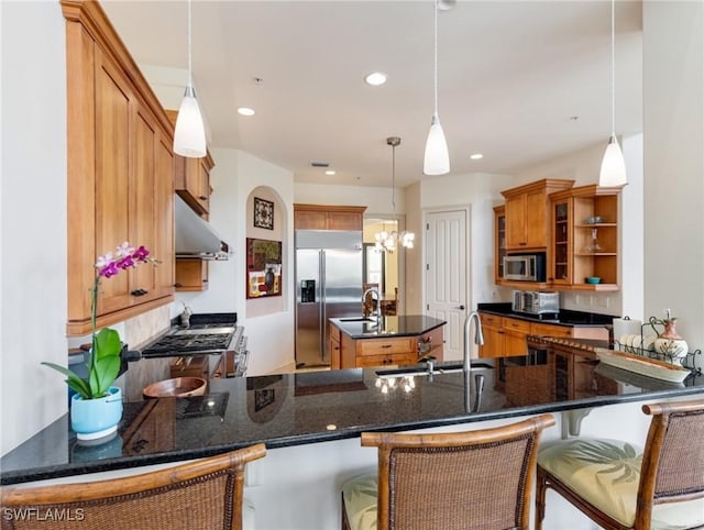 kitchen featuring a breakfast bar area, kitchen peninsula, decorative light fixtures, and appliances with stainless steel finishes