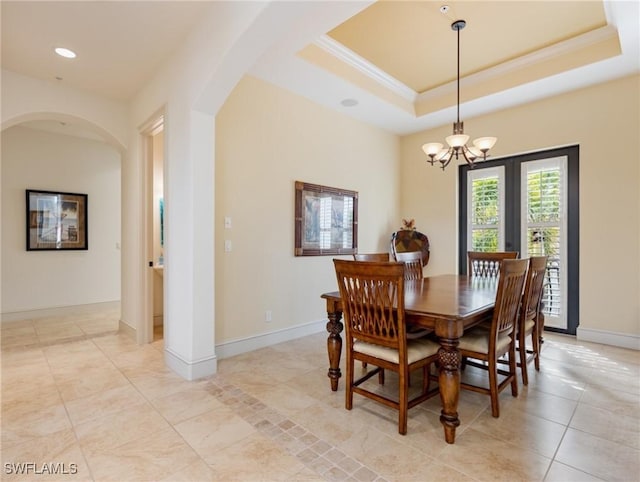 dining room with a tray ceiling and a chandelier