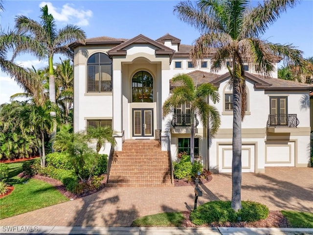 mediterranean / spanish home with a garage and french doors