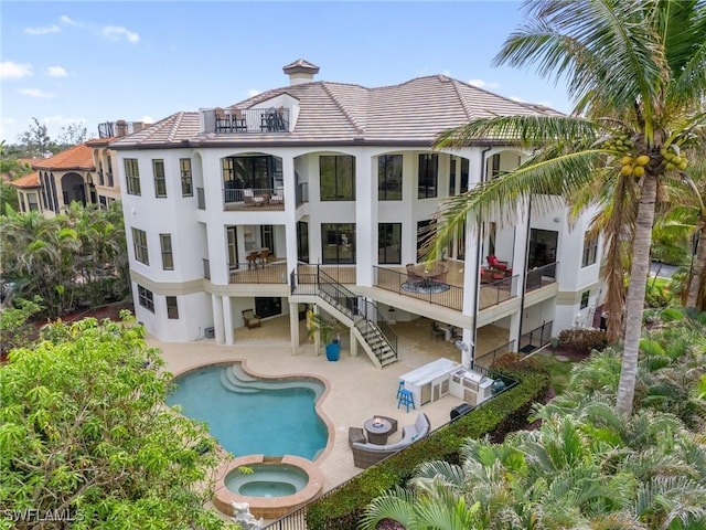 rear view of house featuring a swimming pool with hot tub and a patio area