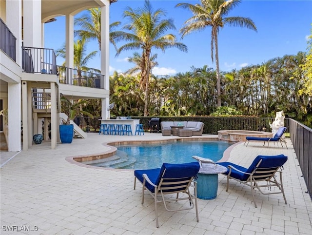 view of pool featuring outdoor lounge area, an in ground hot tub, and a patio