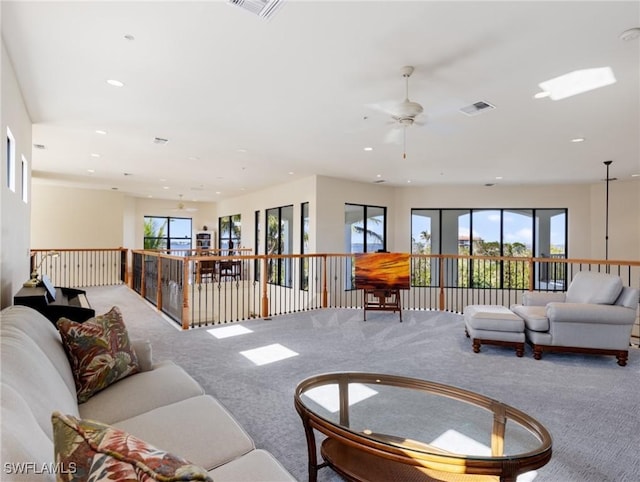 living room featuring a wealth of natural light, carpet floors, and ceiling fan