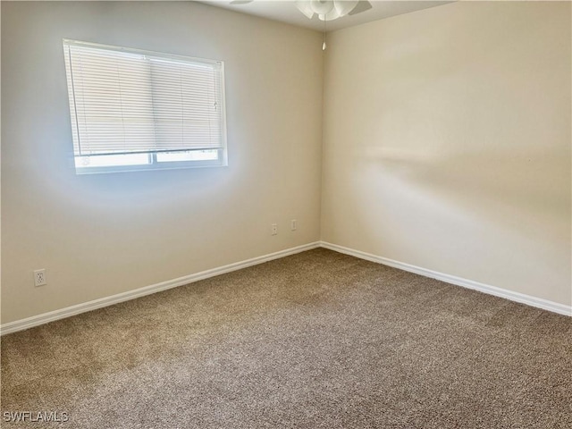 carpeted spare room featuring ceiling fan