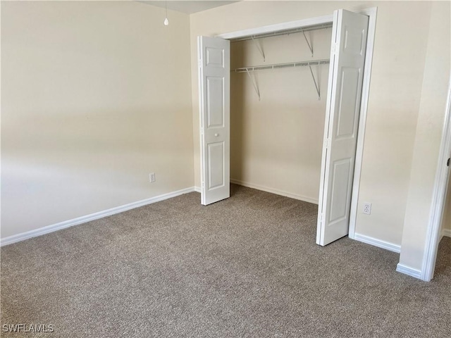 unfurnished bedroom featuring carpet flooring and a closet