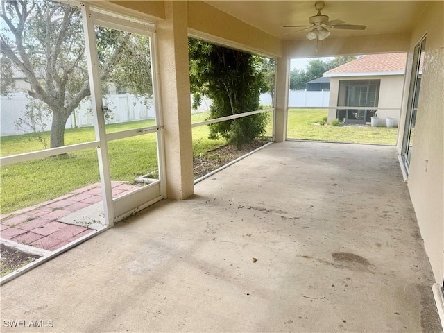 unfurnished sunroom featuring ceiling fan