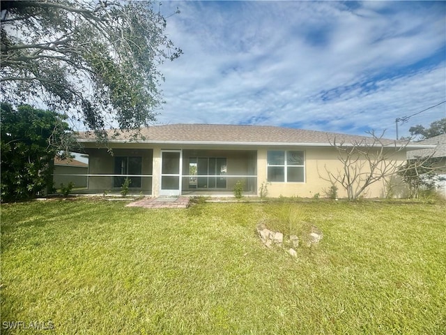 rear view of house with a sunroom and a yard