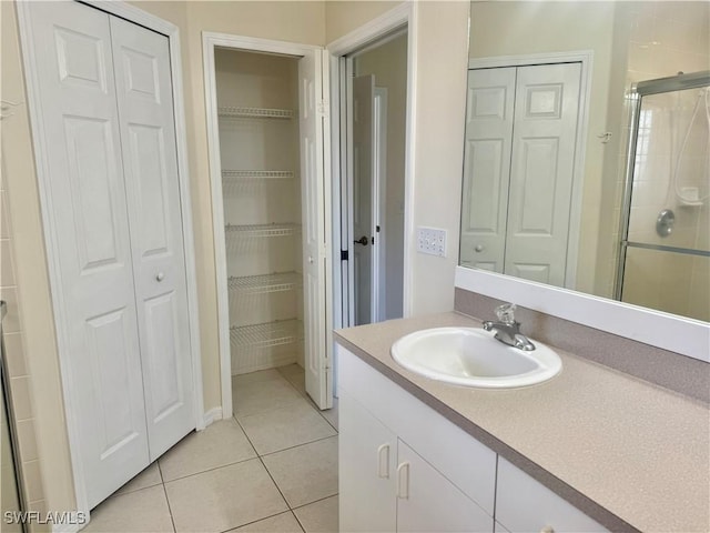 bathroom with tile patterned flooring, vanity, and a shower with shower door