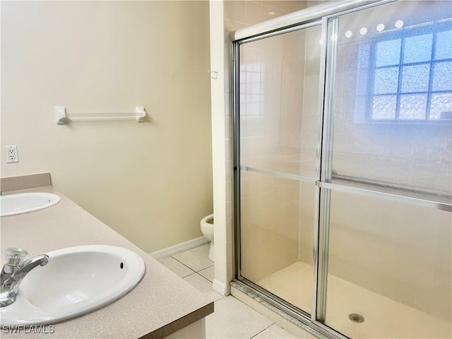 bathroom featuring toilet, vanity, tile patterned floors, and an enclosed shower