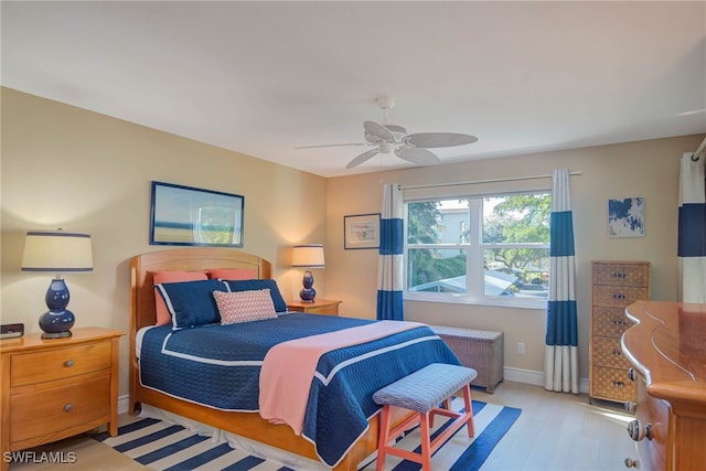 bedroom with ceiling fan, light wood-type flooring, and radiator