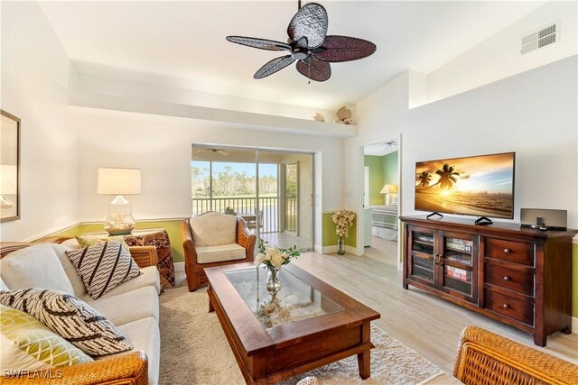 living room with ceiling fan and light hardwood / wood-style flooring