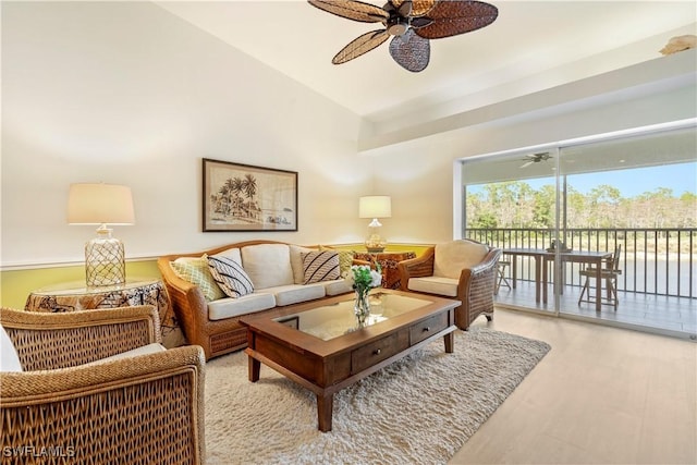 living room featuring ceiling fan, light hardwood / wood-style floors, and vaulted ceiling