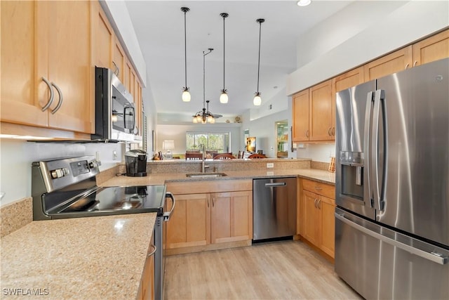 kitchen featuring sink, light hardwood / wood-style flooring, stainless steel appliances, decorative light fixtures, and kitchen peninsula