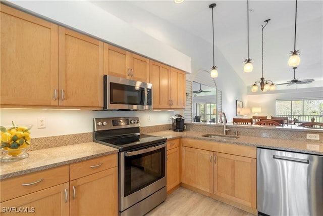 kitchen with sink, plenty of natural light, hanging light fixtures, and appliances with stainless steel finishes