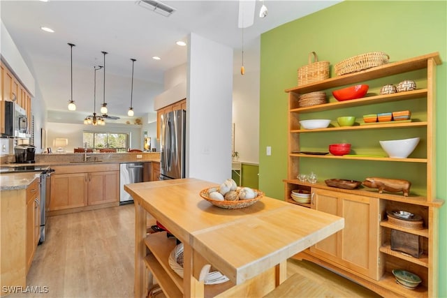 kitchen featuring appliances with stainless steel finishes, light brown cabinetry, sink, kitchen peninsula, and light wood-type flooring