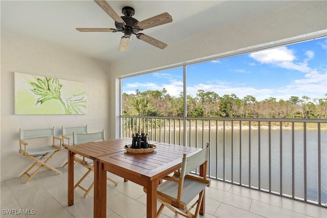 sunroom with a water view and ceiling fan