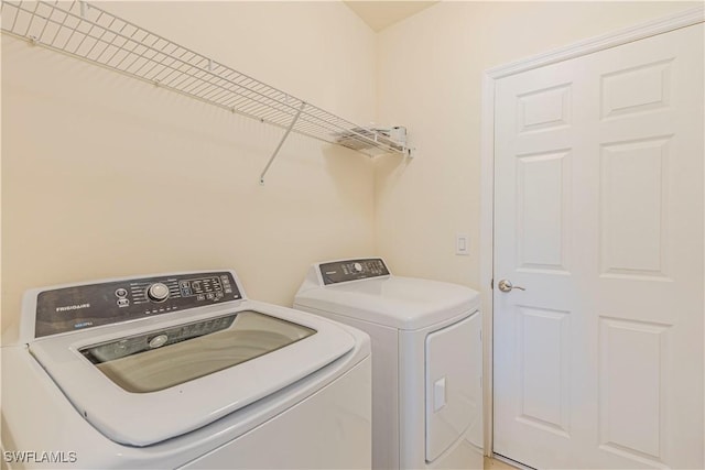 clothes washing area with washing machine and dryer