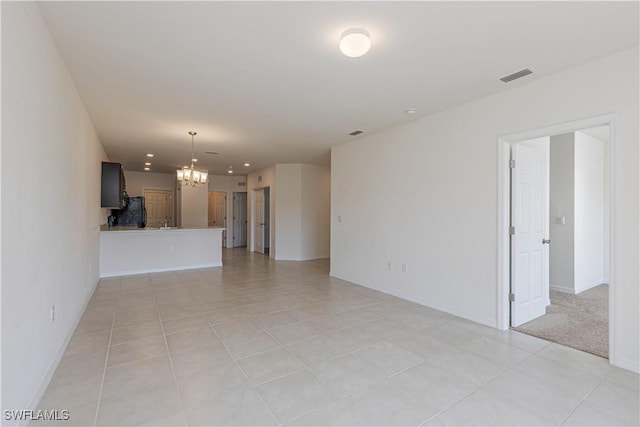 unfurnished living room with light tile patterned floors and a notable chandelier