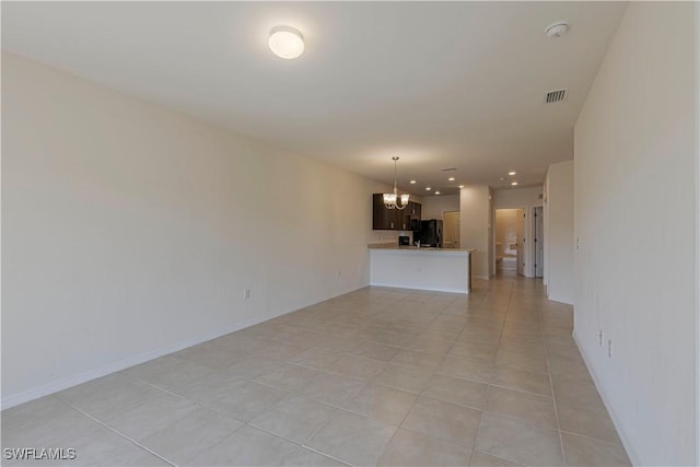 unfurnished living room featuring light tile patterned floors and an inviting chandelier