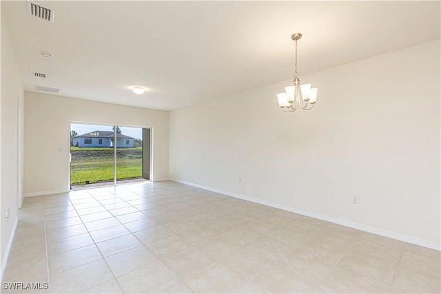 empty room featuring light tile patterned floors and a chandelier