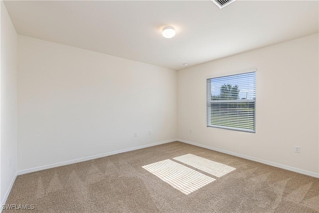 spare room featuring light carpet