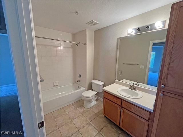 full bathroom with tiled shower / bath combo, tile patterned flooring, a textured ceiling, toilet, and vanity