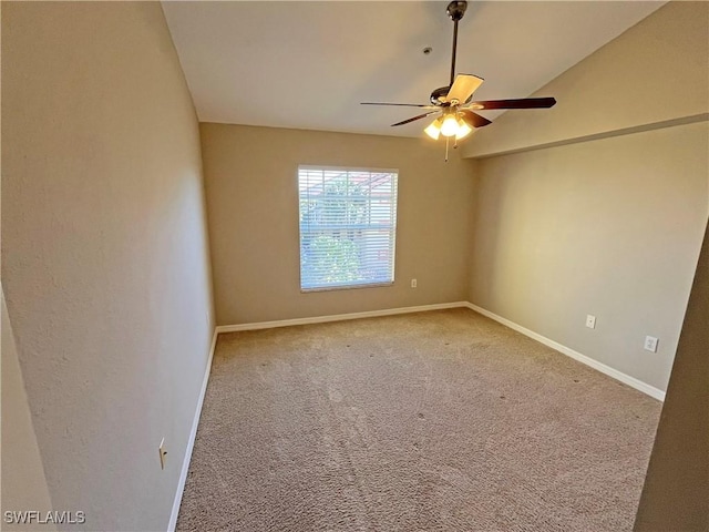 carpeted spare room with ceiling fan and vaulted ceiling