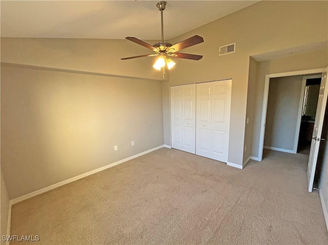 unfurnished bedroom featuring ceiling fan, a closet, high vaulted ceiling, and light colored carpet