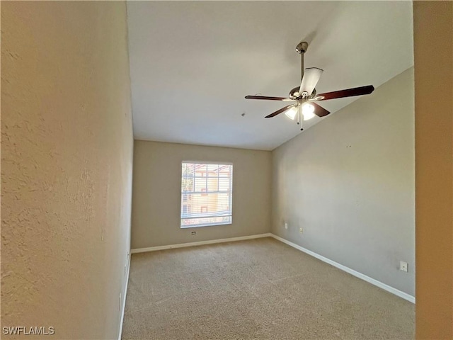 spare room featuring lofted ceiling and light carpet