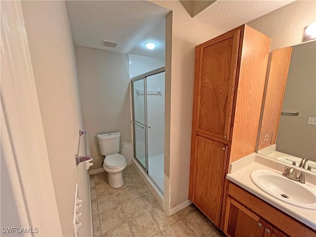 bathroom with a textured ceiling, vanity, toilet, and walk in shower