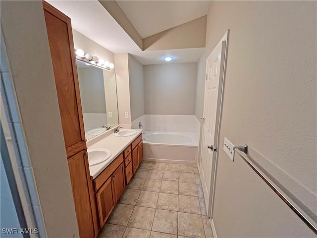 bathroom with tile patterned floors, a washtub, vanity, and vaulted ceiling