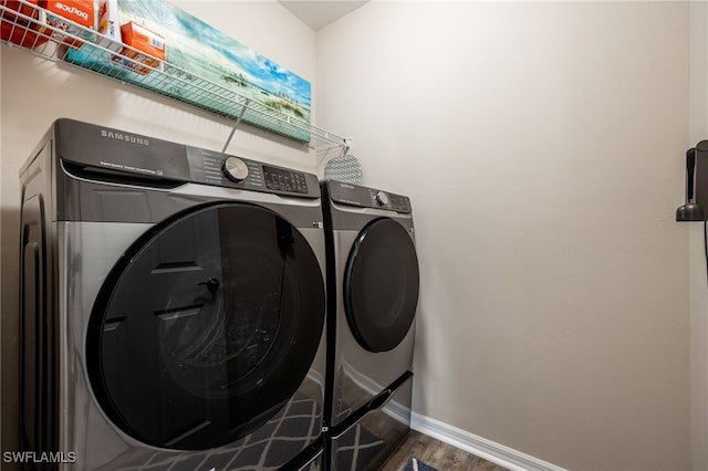 clothes washing area featuring hardwood / wood-style floors and washing machine and clothes dryer