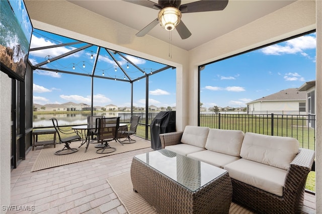 sunroom / solarium with a water view and ceiling fan