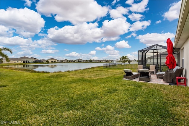 view of yard with a lanai, a patio area, and a water view