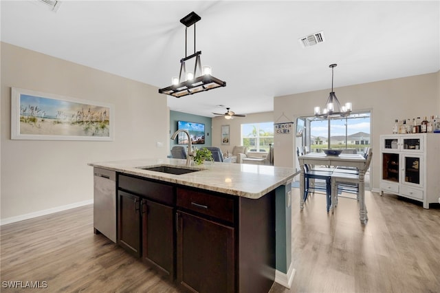 kitchen with light wood-type flooring, ceiling fan with notable chandelier, sink, pendant lighting, and dishwasher