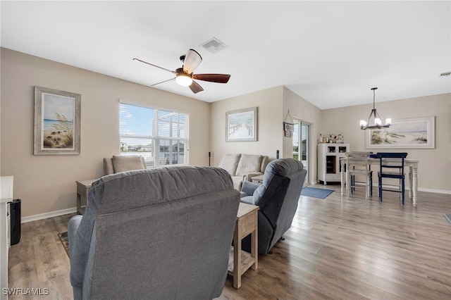 living room with hardwood / wood-style flooring and ceiling fan with notable chandelier